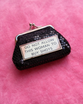Black sequined purse with a humorous message on a pink background