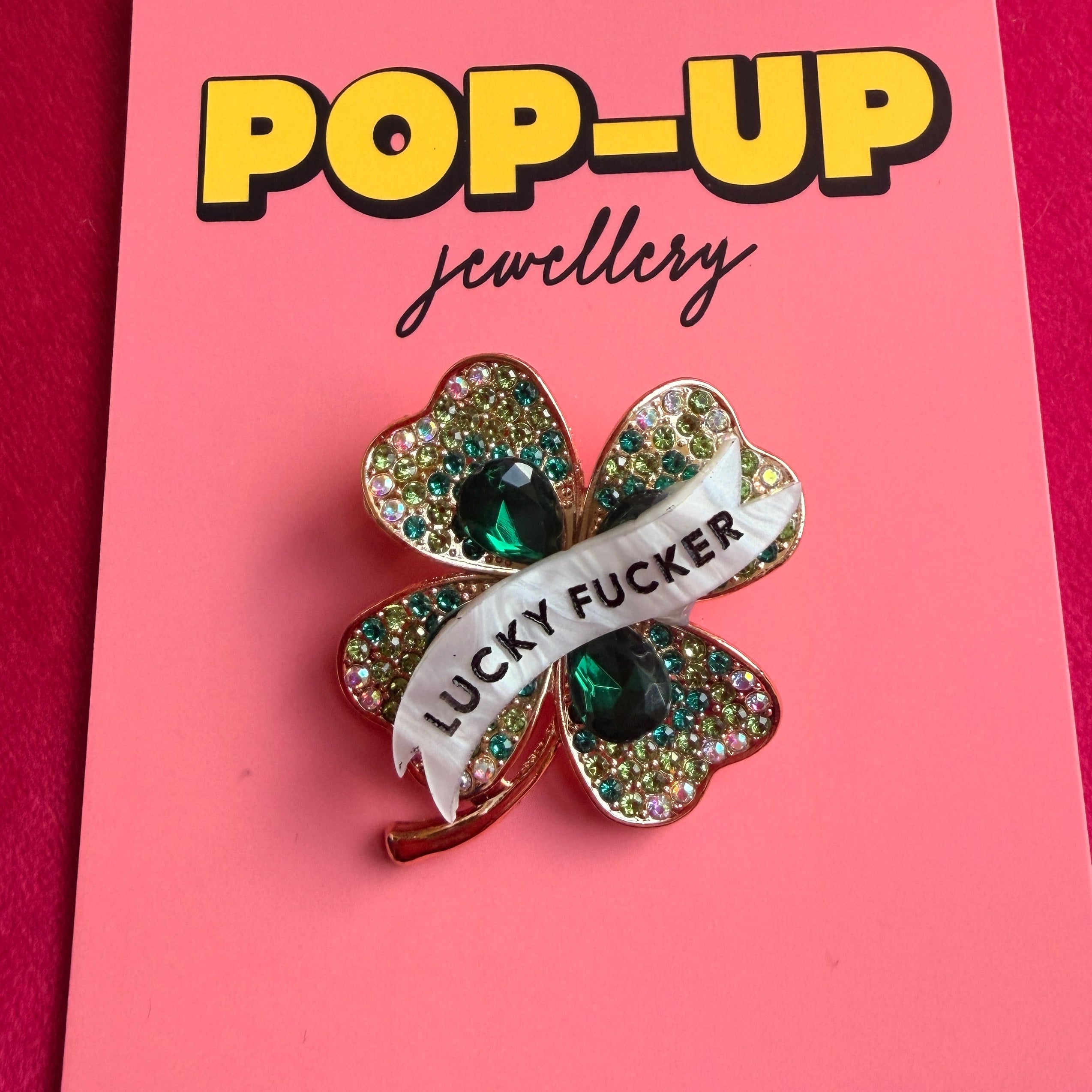 LUCKY FUCKER, diamanté shamrock pin.